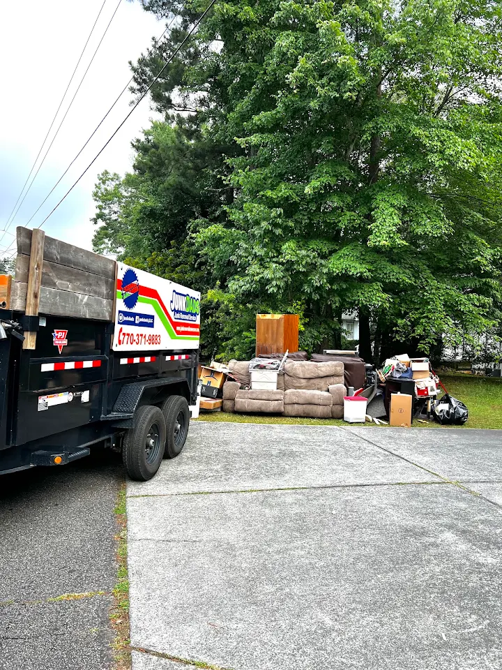 Junk Dads trailer next to a curbside pile of couches, bins and boxes